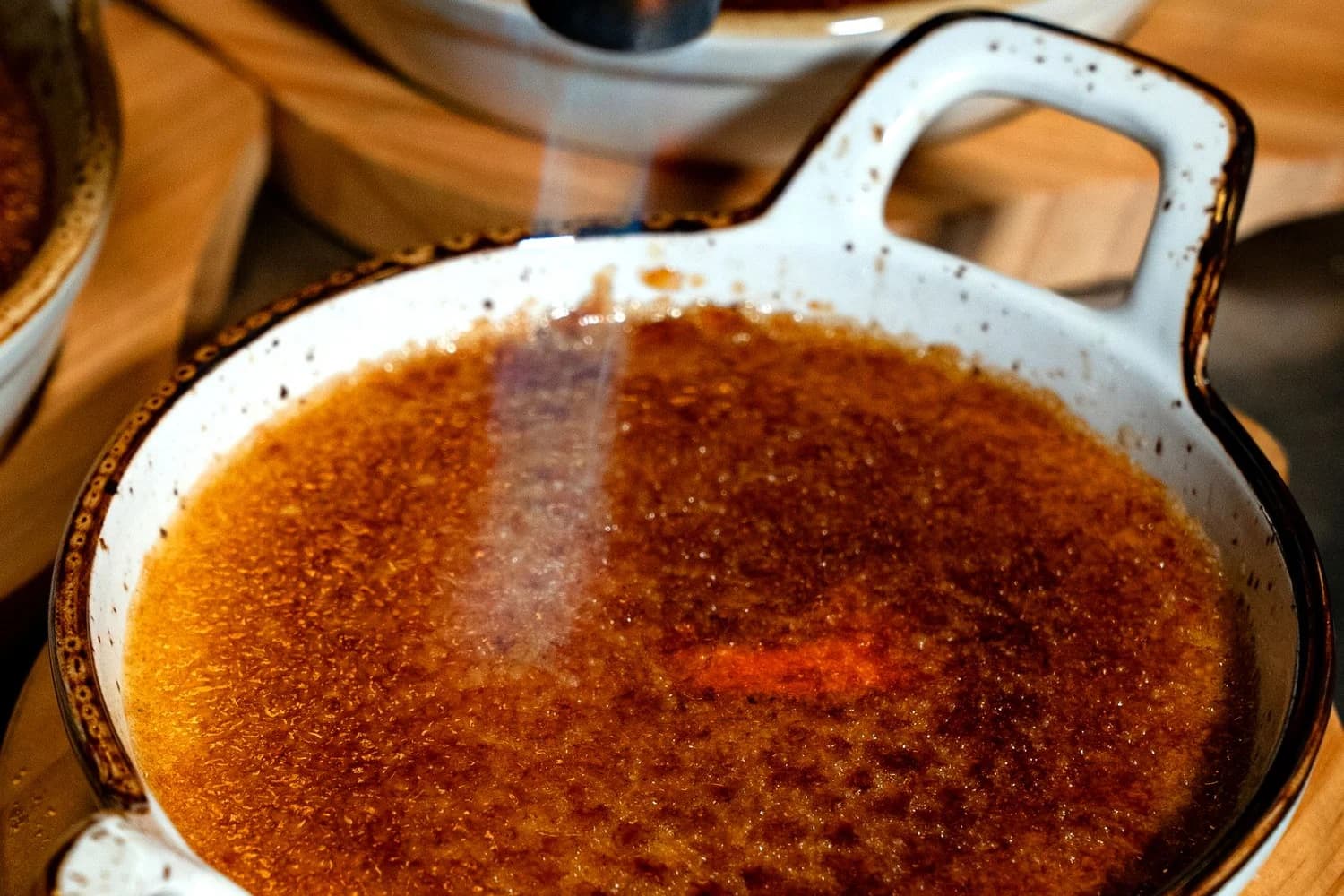 Zucchero della crème brûlée caramellizzato con un cannello, con superficie ambrata